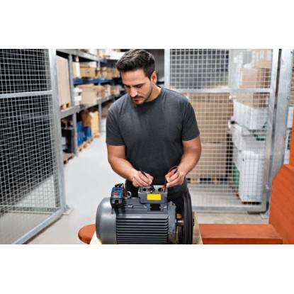 Muž testuje motor s vidlicovým ampérmetrem Bosch Professional GFM 1000-15. Měřicí nástroj v provozu. Muž testuje motor s vidlicovým ampérmetrem Bosch Professional GFM 1000-15. Měřicí nástroj v provozu.