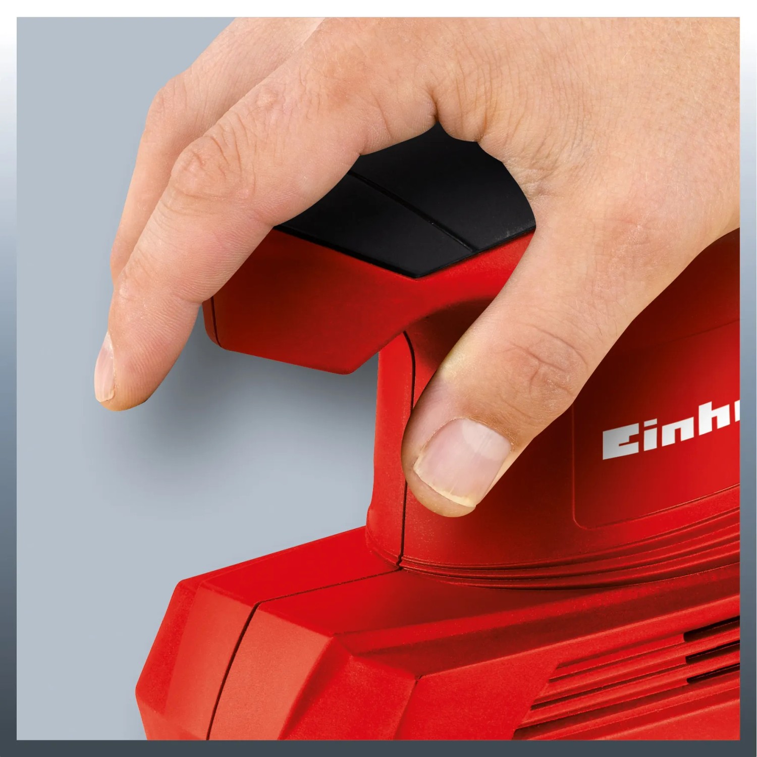 Einhell TC-OS 1520 vibrační bruska v provozu, červená bruska s rukou na spínači. Einhell TC-OS 1520 vibrační bruska v provozu, červená bruska s rukou na spínači.