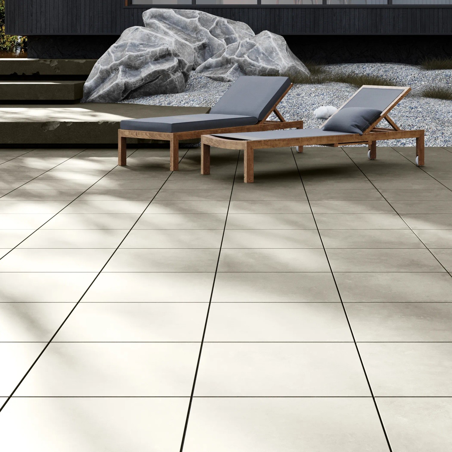 Položené béžové terasové dlaždice z porcelánové kameniny Tuscany Stone 60x60 cm se dvěma lehátky ve venkovním prostoru. Položené béžové terasové dlaždice z porcelánové kameniny Tuscany Stone 60x60 cm se dvěma lehátky ve venkovním prostoru.
