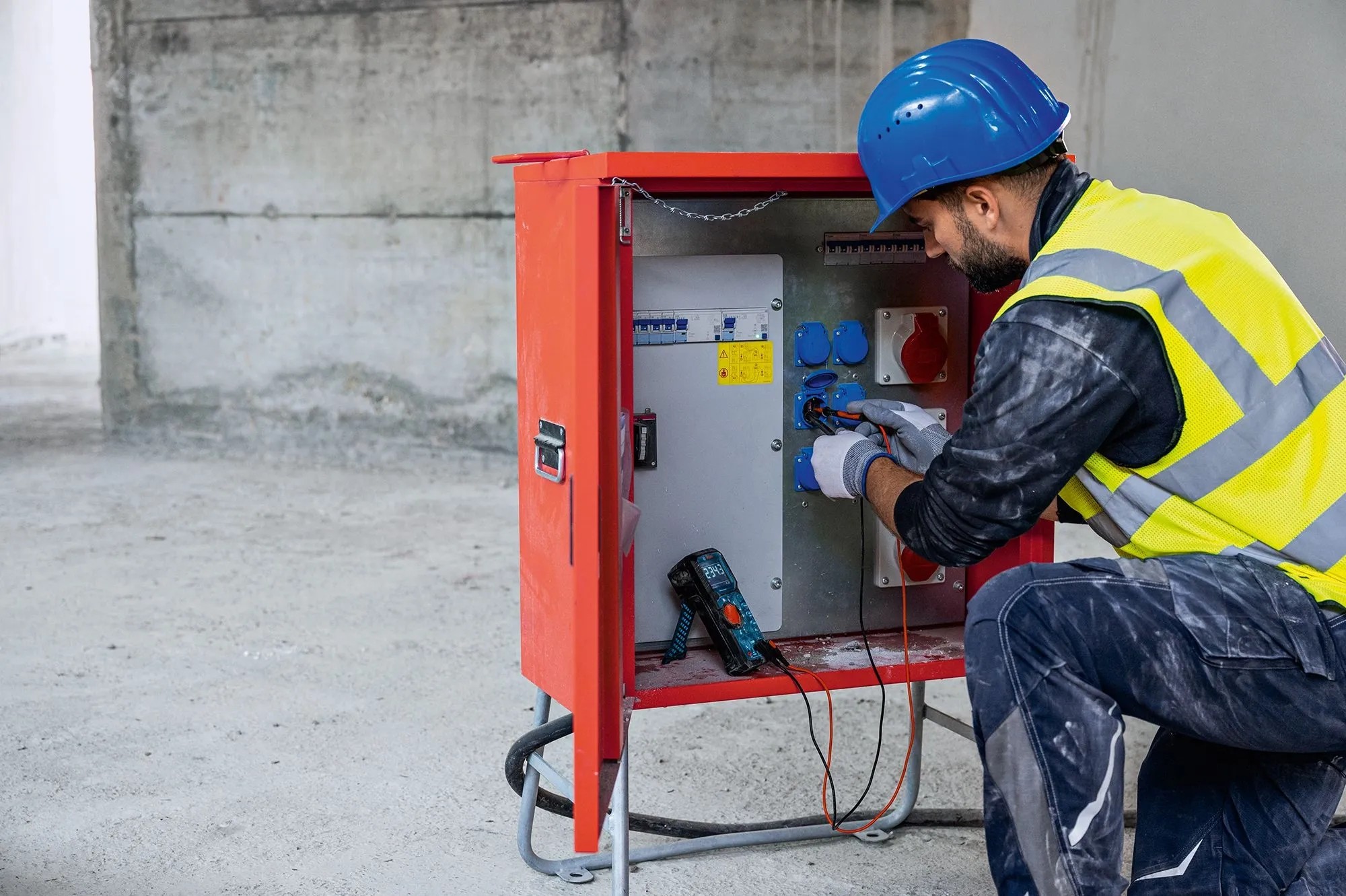 Elektrikář měří proud pomocí digitálního multimetru Bosch Professional GDM 600-15 na rozvodné skříni. Elektrikář měří proud pomocí digitálního multimetru Bosch Professional GDM 600-15 na rozvodné skříni.