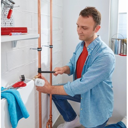 Muž opravuje trubku pomocí Tesa extra Power Repair Tape Extreme, černá. Muž opravuje trubku pomocí Tesa extra Power Repair Tape Extreme, černá.