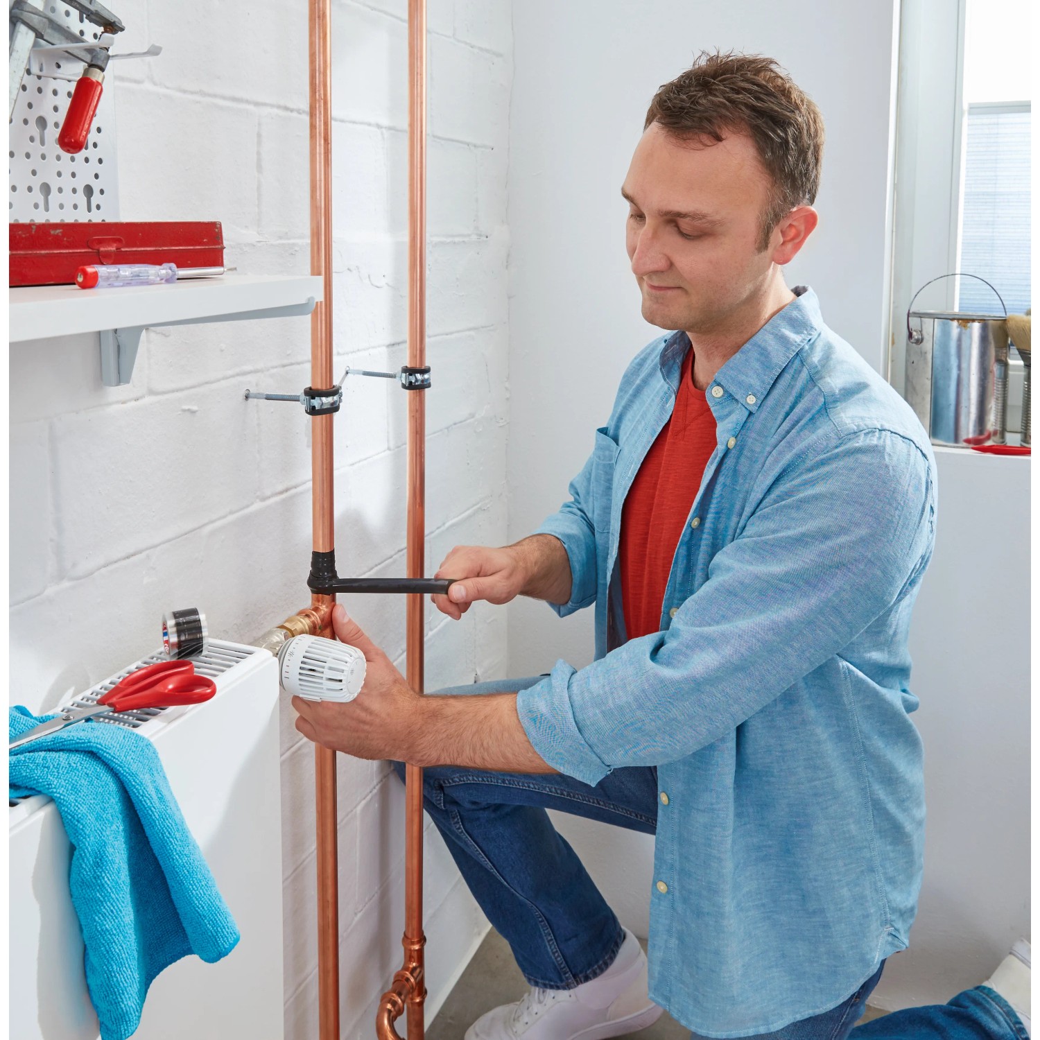 Muž opravuje trubku pomocí Tesa extra Power Repair Tape Extreme, černá. Muž opravuje trubku pomocí Tesa extra Power Repair Tape Extreme, černá.