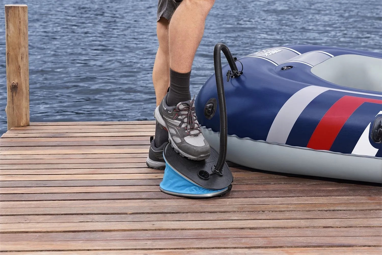 Nožní pumpa Bestway Air Step Pro nafukuje člun na dřevěném mole. Nožní pumpa Bestway Air Step Pro nafukuje člun na dřevěném mole.