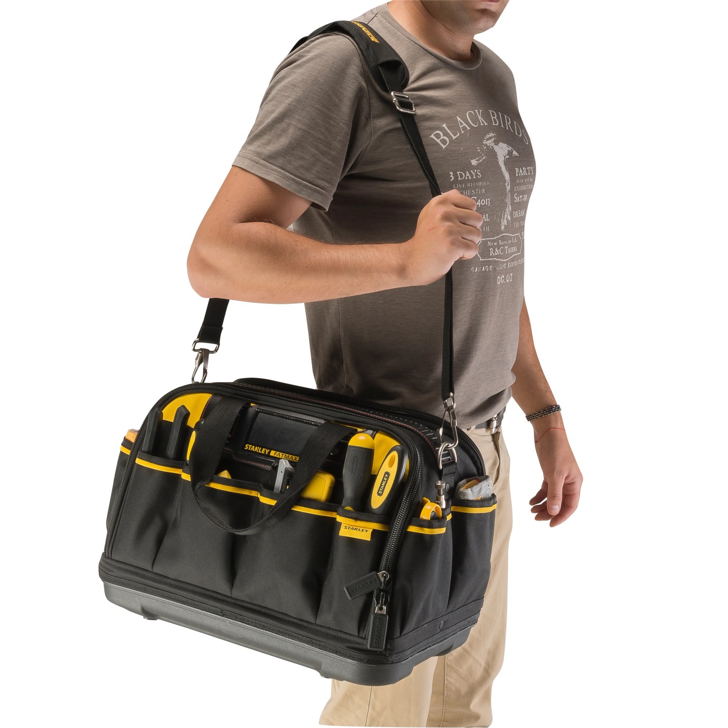 Brašna na nářadí Stanley FatMax FMST1-73607, kterou nese osoba. Černo-žlutý kufr na nářadí. Brašna na nářadí Stanley FatMax FMST1-73607, kterou nese osoba. Černo-žlutý kufr na nářadí.