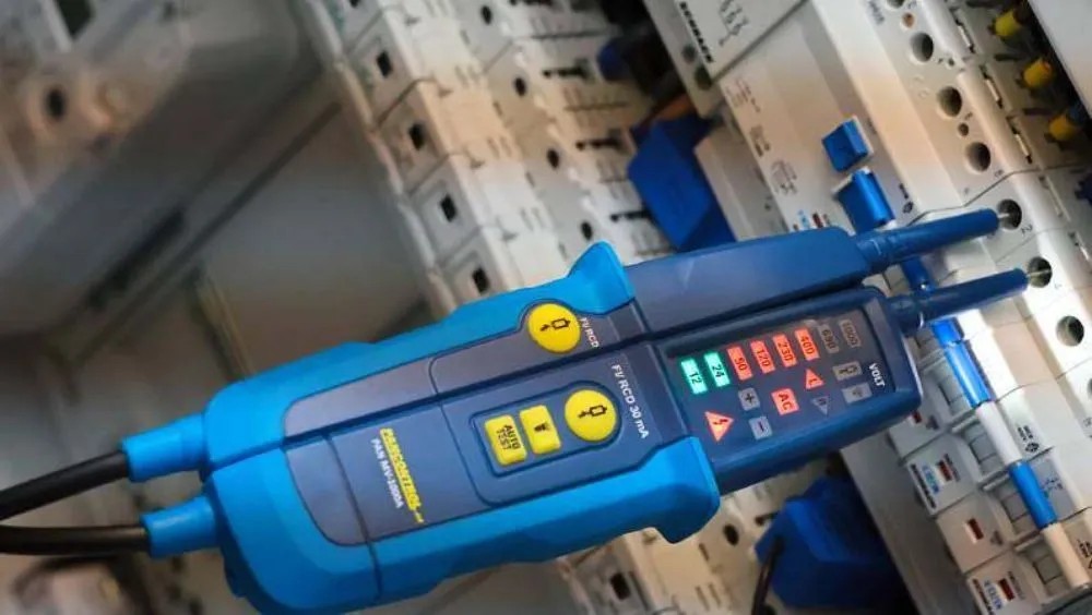 Zkoušečka napětí Pancontrol PAN MV-1000A, 12-1000 V, s LED displejem a testovacími hroty před rozvodnou skříní. Zkoušečka napětí Pancontrol PAN MV-1000A, 12-1000 V, s LED displejem a testovacími hroty před rozvodnou skříní.