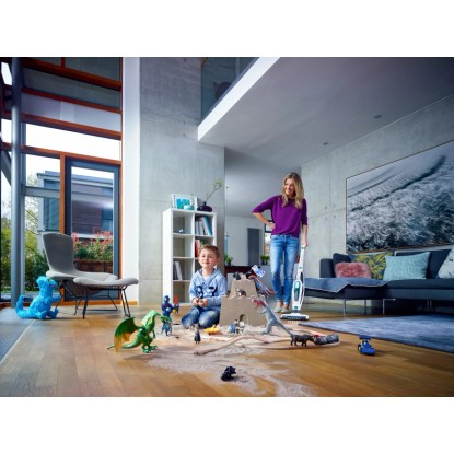 Akumulátorový vysavač Leifheit Regulus PowerVac v akci, matka vysává prach z hraček, dítě si hraje. Akumulátorový vysavač Leifheit Regulus PowerVac v akci, matka vysává prach z hraček, dítě si hraje.
