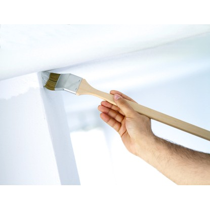 Rohový štětec LUX 50 mm v akci: Ruka maluje roh disperzní barvou. Rohový štětec LUX 50 mm v akci: Ruka maluje roh disperzní barvou.