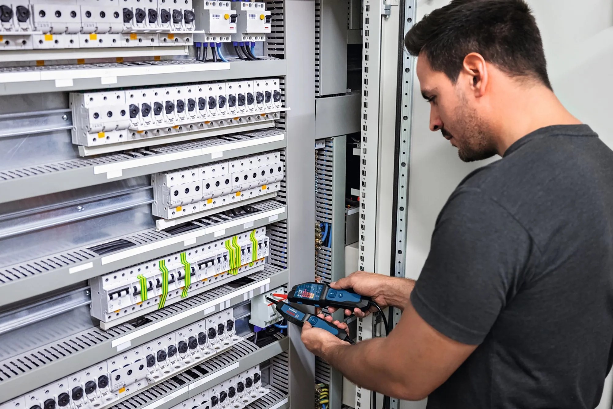 Elektrikář testuje napětí pomocí zkoušečky napětí Bosch Professional GVT 1000-15 na rozvaděči. Elektrikář testuje napětí pomocí zkoušečky napětí Bosch Professional GVT 1000-15 na rozvaděči.