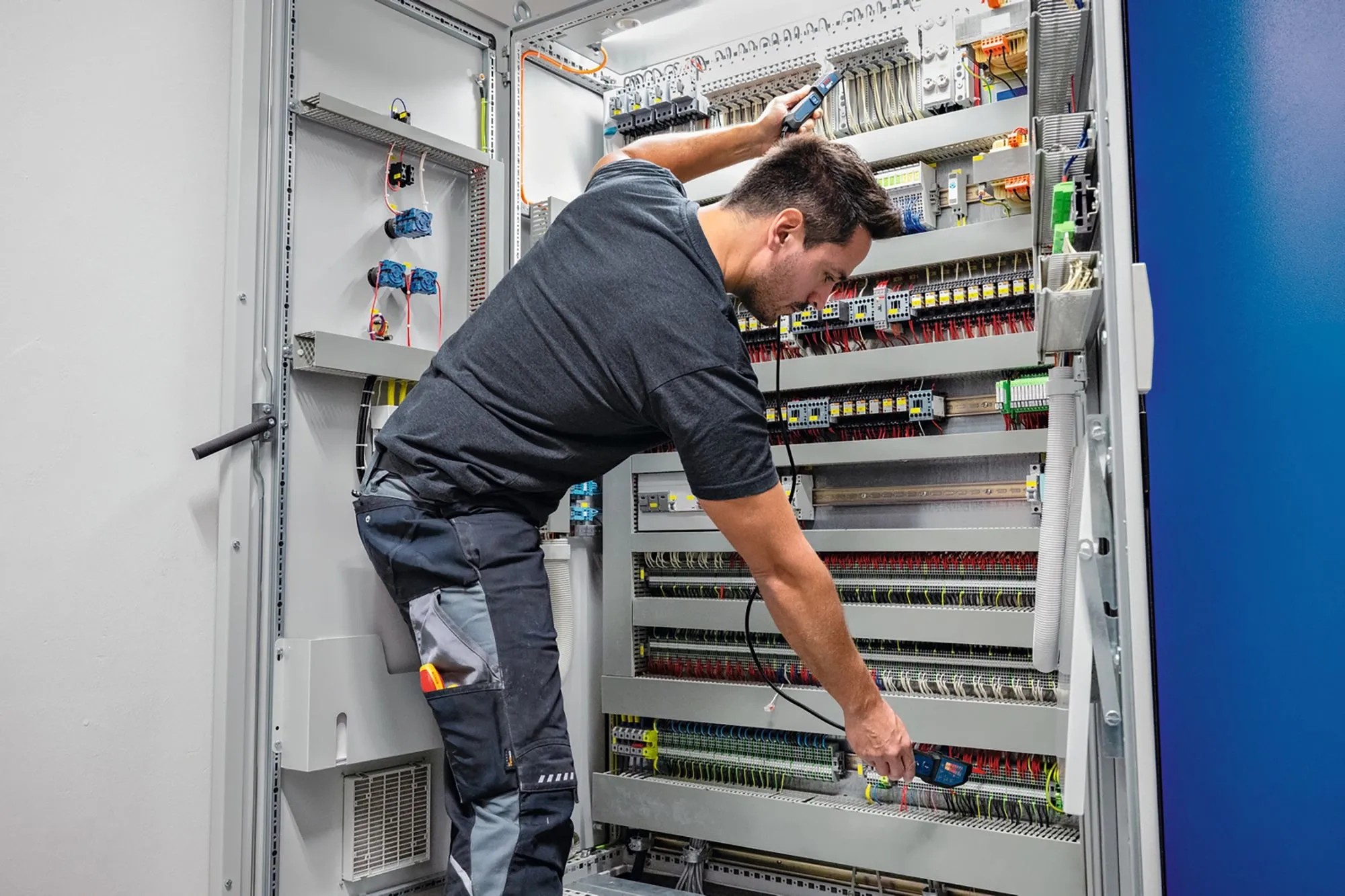 Elektrikář kontroluje napětí pomocí zkoušečky Bosch Professional GVT 1000-15 na rozvaděči. Elektrikář kontroluje napětí pomocí zkoušečky Bosch Professional GVT 1000-15 na rozvaděči.