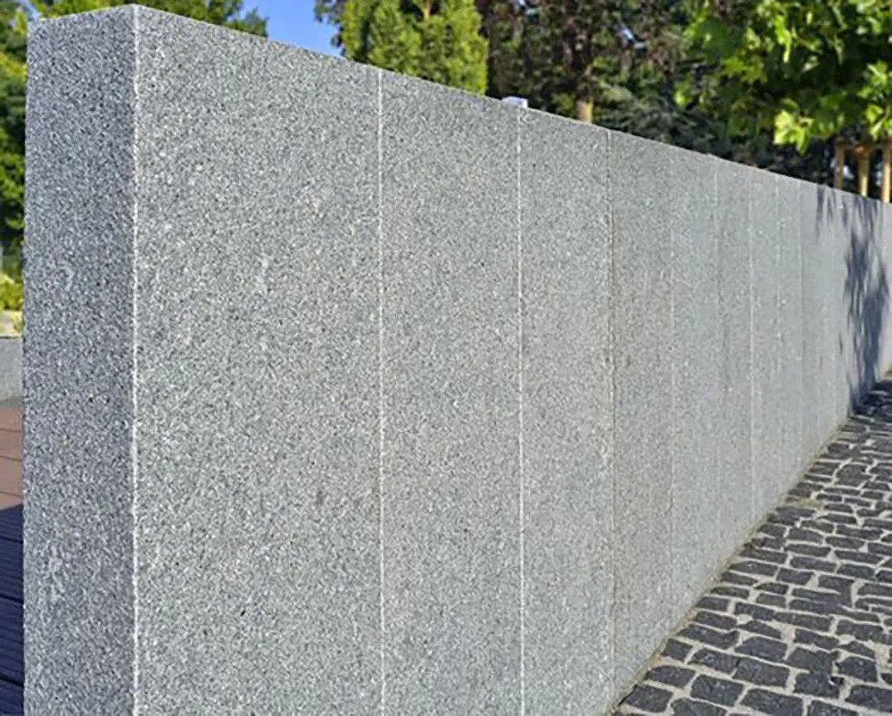 Antracitově šedá žulová palisáda, řezaná a plamenovaná, jako zahradní obruba nebo zeď. Antracitově šedá žulová palisáda, řezaná a plamenovaná, jako zahradní obruba nebo zeď.