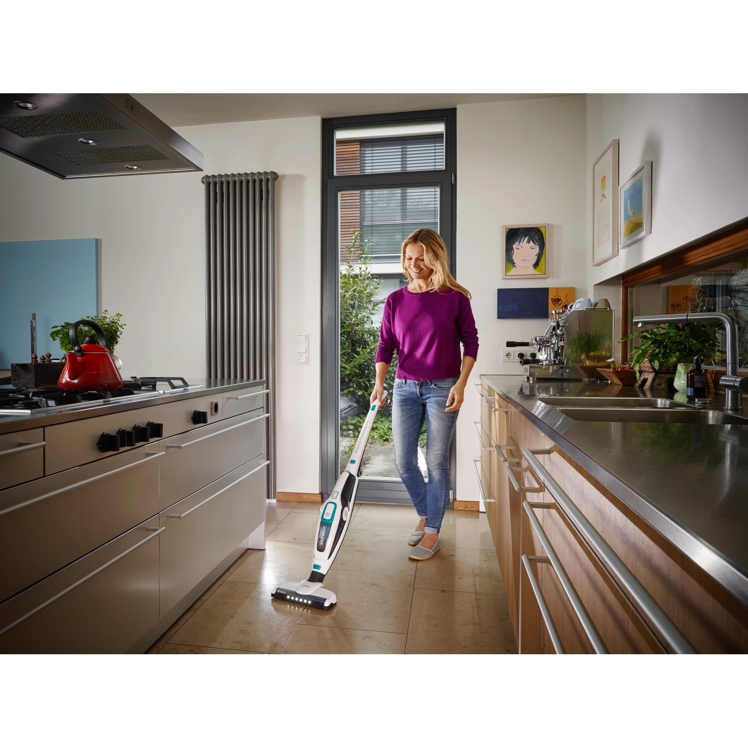 Žena vysává podlahu v kuchyni pomocí akumulátorového vysavače Leifheit Regulus PowerVac. Žena vysává podlahu v kuchyni pomocí akumulátorového vysavače Leifheit Regulus PowerVac.