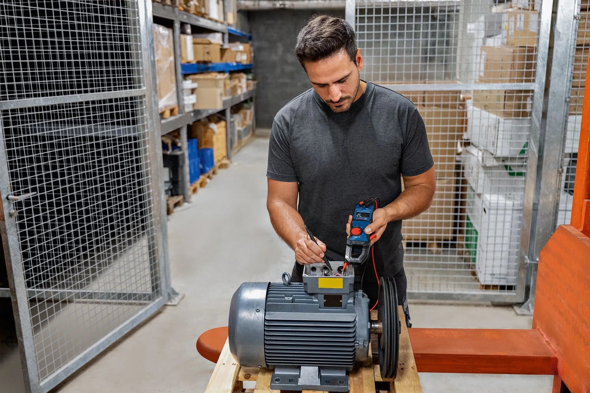 Elektrikář měří elektromotor klešťovým multimetrem Bosch Professional GMC 600-15. Přesný, robustní měřicí nástroj. Elektrikář měří elektromotor klešťovým multimetrem Bosch Professional GMC 600-15. Přesný, robustní měřicí nástroj.