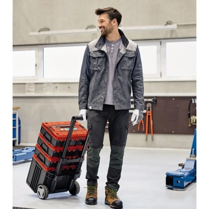 Muž táhne kufřík na nářadí Einhell E-Case L s kolečky. Mobilní přeprava nářadí.