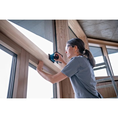 Žena brousí okenní rám akumulátorovou vibrační bruskou Bosch Professional GSS 12V-123.