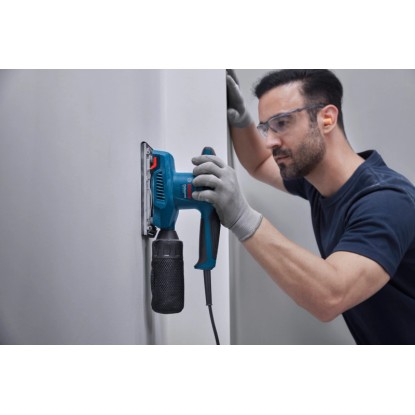 Excentrická bruska Bosch Professional GSS 20-18 A při broušení stěny.