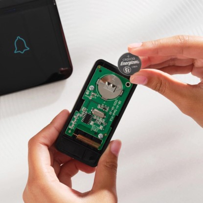 Lithiová knoflíková baterie Energizer CR2032 vkládaná do elektronického zařízení.