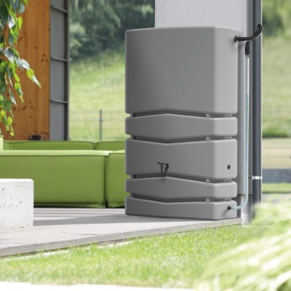 Šedý sud na dešťovou vodu Waterform Aqua Tower 350 l v zahradě s přívodní trubkou.